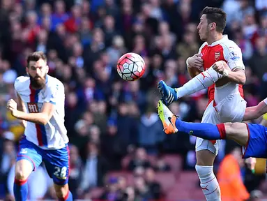 Gelandang Arsenal, Mesut Ozil, berebut bola dengan gelandang Crystal Palace, Yohan Cabaye, pada laga Liga Premier Inggris di Stadion Emirates, London, Minggu (17/4/2016). Kedua tim bermain imbang 1-1. (AFP/Ben Stansall)