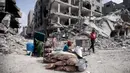 Warga Palestina duduk di dekat barang-barang mereka setelah mengunjungi rumah mereka yang hancur dalam serangan Israel di Khan Younis, Jalur Gaza, Rabu, 6 Maret 2024. (AP Photo/Mohammed Dahman)