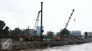 Alat berat dikerahkan untuk memasang pasak di bantaran Kali Ciliwung, Bukit Duri, Jakarta (1/11). Pemasangan tiang pancang untuk sheet pile di kali tersebut ditargetkan hingga 2000 meter dan selesai akhir Desember 2016. (Liputan6.com/Gempur M Surya)