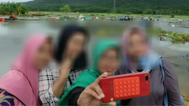 Sejumlah orang selfie di depan lokasi bencana tsunami Banten