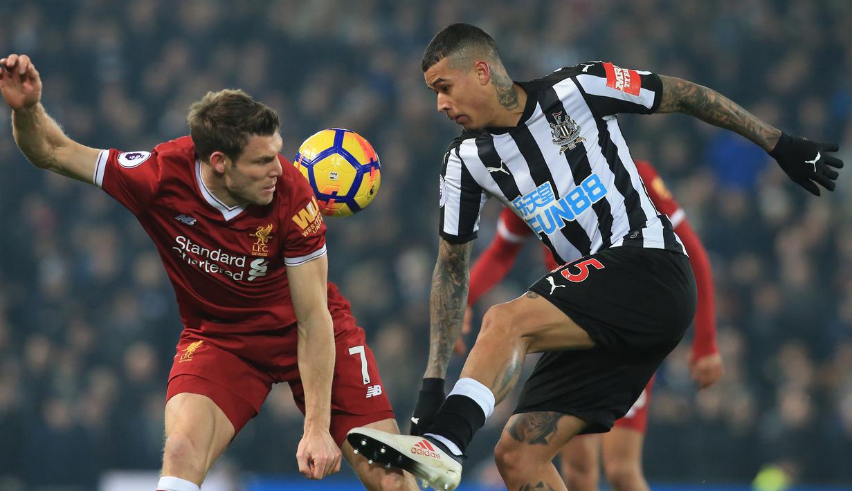Pemain Liverpool, James Milner (kiri) berebut bola dengan pemain Newcastle United, Kenedy pada lanjutan Premier League di Anfield, Liverpool, (3/3/2018). Liverpool menang 2-0.  (AFP/Lindsey Parnaby)