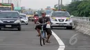 Akibat banjir di kawasan Jalan Yos Sudarso, Jakarta, seorang pesepeda melintasi jalan tol Wiyoto Wiyono, Senin (10/2/2015). (Liputan6.com/Herman Zakharia)