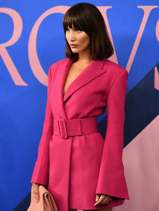 Pose Bella Hadid saat menghadiri acara CFDA Fashion Awards di Manhattan, New York, (5/6). Model 20 tahun ini tampil cantik dan seksi mengenakan jaket kulit sapi berwarna pink. (Dimitrios Kambouris/Getty Images North America/AFP)