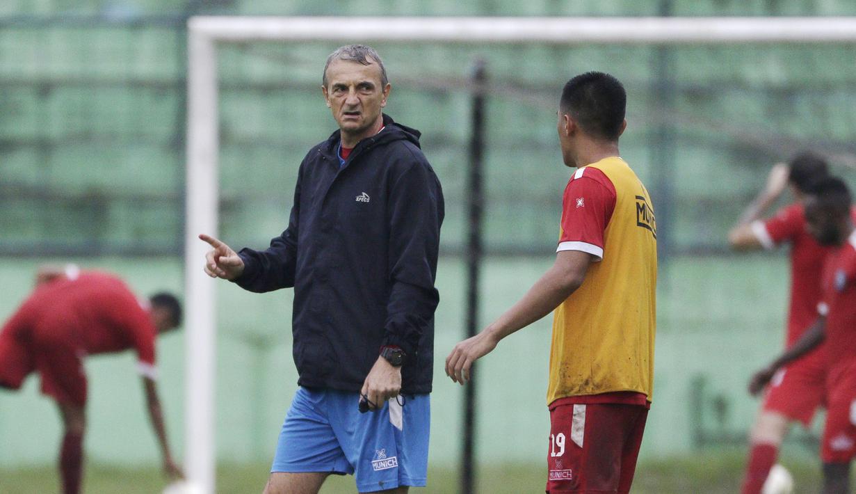 Pelatih Arema FC, Milomir Seslija, berbincang dengan Hanif Sjahbandi saat sesi latihan di Stadion Gajayana, Malang, Kamis (11/4). Latihan ini merupakan persiapan jelang laga final menghadapi Persebaya Surabaya. (Bola.com/Yoppy Renato)