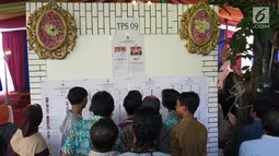 Warga melihat daftar nama caleg pada Pemilu 2019 di TPS 09 Kelurahan Sambirejo yang berkonsep pesta pernikahan di Semarang, Rabu (17/4). TPS itu dihiasi dengan dekorasi mewah dan menarik layaknya tempat pesta pernikahan agar semua warga senang ketika datang untuk mencoblos. (Liputan6.com/Gholib)