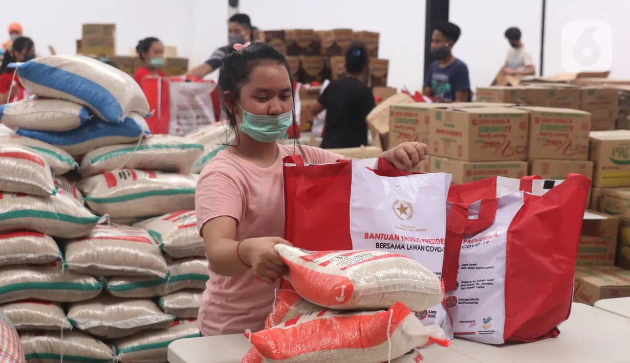 Pekerja sedang mengemas bantuan paket sembako dari Presiden Joko Widodo di Tangerang, Sabtu (9/6/2020).  Ribuan paket sembako tersebut akan didistribusikan kepada warga kurang mampu di wilayah Bodetabek guna mengurangi beban ekonomi mereka di tengah pandemi COVID-19. (Liputan6.com/Angga Yuniar)