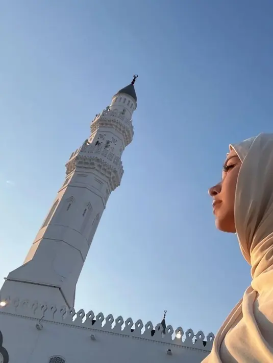 Tak hanya di Madinah, Alssa juga memukau saat berada di Masjid Quba. Dalam salah satu foto, ia terlihat mengenakan hijab putih lembut dengan latar belakang menara masjid yang indah saat senja. Penampilan tersebut menuai pujian karena menonjolkan sisi anggun Alyssa Daguise yang baru kali ini tampil berhijab. (Liputan6.com/IG/@alyssadaguise)