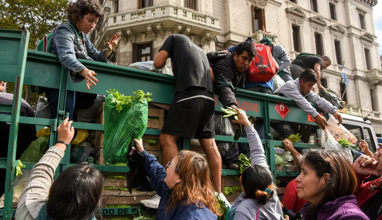 Petani menyerahkan 20 ton hasil panen untuk memprotes tingginya biaya hidup petani dan permintaan kredit untuk membeli tanah di Buenos Aires, Senin (24/4). (AFP FOTO / Eitan ABRAMOVICH)