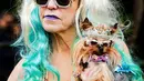 Seorang wanita menggendong anjingnya saat ikut ambil bagian dalam parade Halloween Dog di Tompkins Square Park Manhattan, New York, AS, Sabtu (22/10). Parade Halloween khusus anjing ini digelar setiap tahun. (REUTERS/Eduardo Munoz)