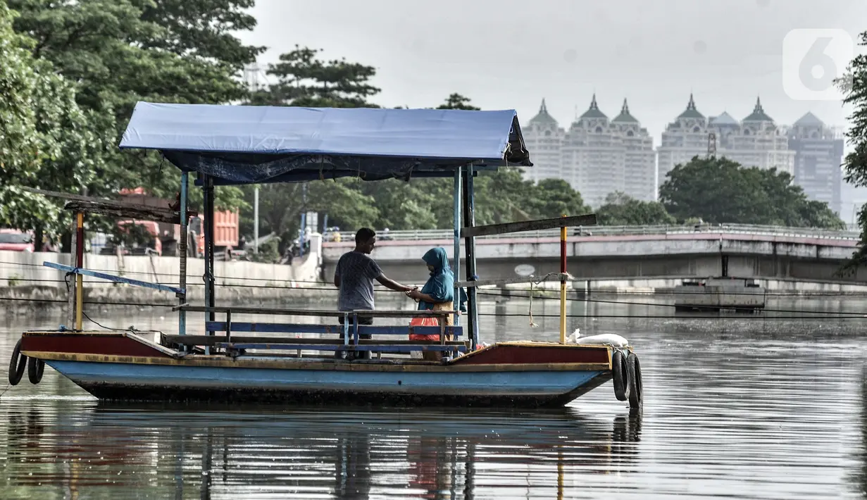 Warga menaiki perahu eretan saat menyeberangi Kali Sunter, Rawa Badak, Jakarta, Rabu (20/1/2021). Penumpang dikenai tarif Rp 1.000-2.000 sekali jalan. (merdeka.com/Iqbal S. Nugroho)