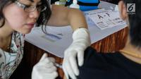 Seorang mahasiswa saat disuntik vaksin difteri di Universitas Tarumanegara, Jakarta, Kamis (14/5). Ratusan mahasiswa/wi yang berusia di bawah 19 tahun mendapatkan imunisasi (Td) sebagai antisipasi mewabahnya penyakit difteri. (Liputan6.com/Faizal Fanani)