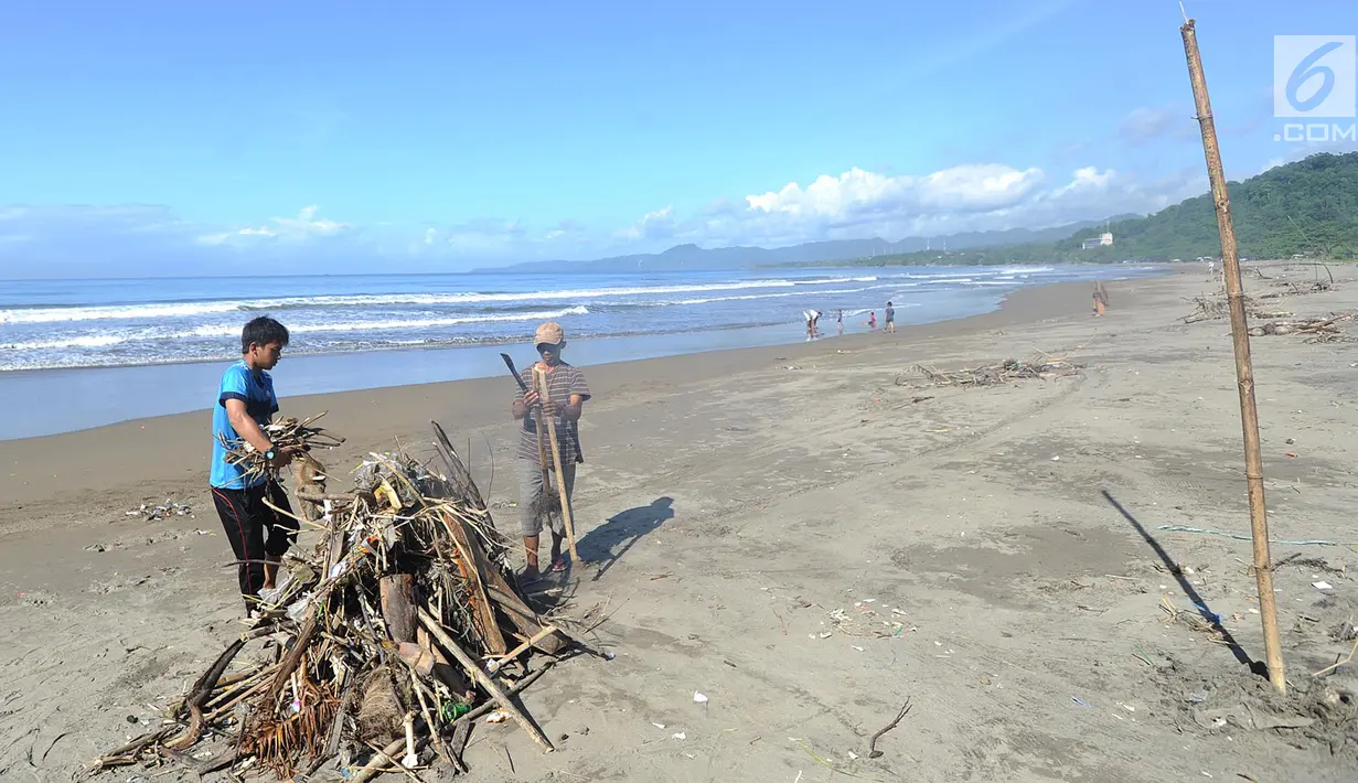 Sukarelawan membakar sampah yang berserakan akibat terbawa ombak pasang di kawasan Pantai Citepus, Pelabuhan Ratu, Sukabumi, Jumat (4/1). Aksi ini didasari atas kesadaran warga mengenai kebersihan pantai. (Merdeka.com/Arie Basuki)