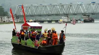 Perahu hias Festival Serayu Banyumas 2018 berlayar dengan latar Jembatan Kereta Api yang melintang di atas Sungai Serayu. (Foto: Liputan6.com/FSB 2018/Muhamad Ridlo)