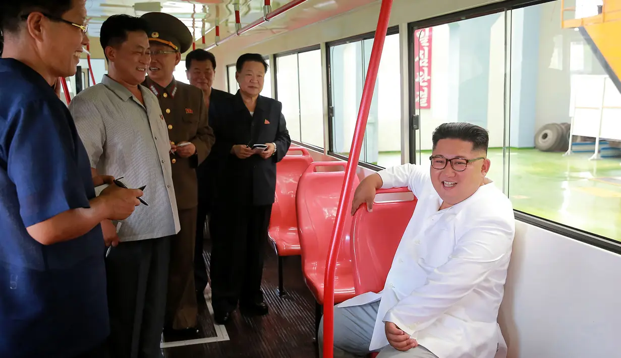 Pemimpin Korea Utara Kim Jong-Un tersenyum saat duduk di dalam bus jenis baru yang diproduksi selama kunjungan ke pabrik bus di Pyongyang, (4/8). (AFP Photo/KCNA)