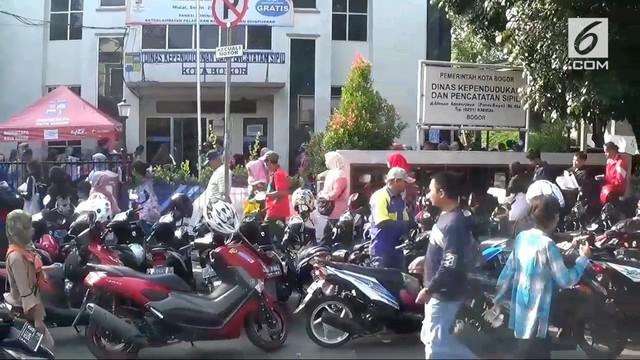Ribuan warga Bogor mengantre E-KTP di Disdukcapil setempat. Penuhnya tempat membuat masyarakat antre hingga ke jalan raya.