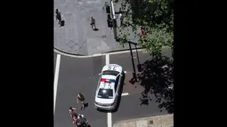 Sebuah mobil polisi menutup jalan di sekitar lokasi penyanderaan di The Lindt Chocolate Cafe, Sydney, Senin (15/12/2014). (Istimewa)