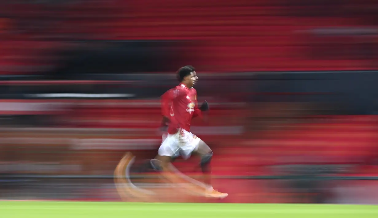 Pemain Manchester United, Marcus Rashford berlari mengejar bola pada laga babak keempat FA Cup 2020-21 melawan Liverpool di Old Trafford, Senin (25/01/2021). (Foto: AP/Pool/Laurence Griffiths)