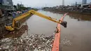 Petugas kebersihkan dibantu alat berat membersihkan sampah di Sungai Kanal Banjir Barat, Jakarta, Senin (14/11). Hujan yang terjadi di hulu Banjir Kanal Barat mengakibatkan meningkatnya debit air yang disertai sampah. (Liputan6.com/Johan Tallo)