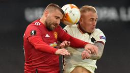 Bek Manchester United, Luke Shaw (kiri) berduel udara dengan bek AS Roma, Rick Karsdorp dalam laga leg pertama semifinal Liga Europa 2020/2021 di Old Trafford Stadium, Manchester, Kamis (29/4/2021). Manchester United menang 6-2 atas AS Roma. (AFP/Paul Ellis)