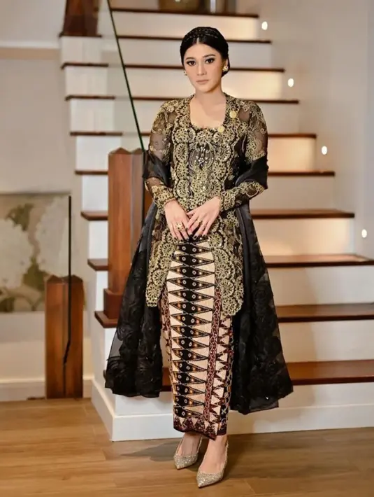 Naysila Mirdad mengenakan kebaya kutu baru hitam dengan embroidery emas dipadukan selendang hitam dan bawahan kain batik warna coklat salur hitam.  [@svarna_byikatindonesia]