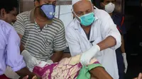 Petugas memakai masker sebagai antisipasi penularan virus Nipah saat membantu pasien di RS Government Medical College, Kozhikode, Kerala, India Selatan, Kamis (24/5). Tidak ada vaksinasi untuk virus yang memiliki tingkat kematian 70 persen ini. (AP Photo)