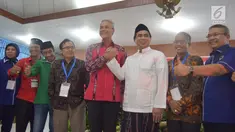 Calon Gubernur Jawa Tengah, Ganjar Pranowo berjabat tangan dengan wakilnya Cawagub Taj Yasin saat mendaftar di KPUD Jateng, Semarang, Selasa (9/1). Pendaftaran paslon ini dilakukan di hari kedua waktu pendaftaran. (Liputan6.com/Gholib)