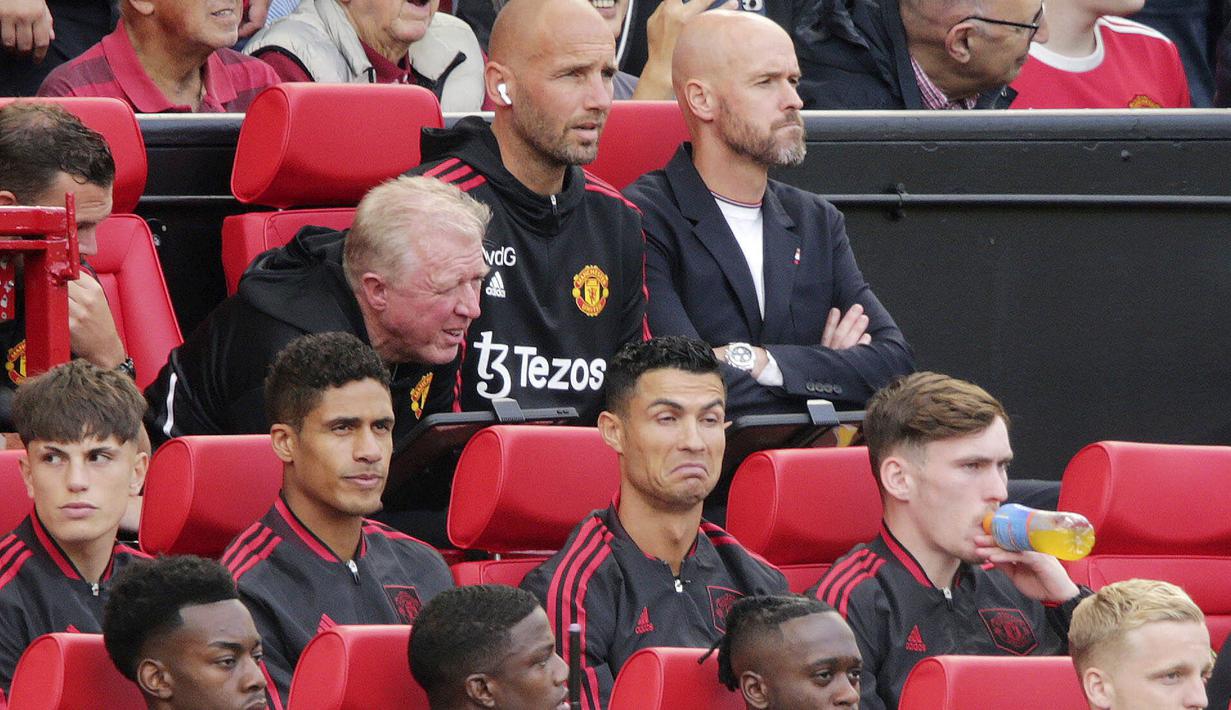 Ekpresi ngenyek pemain Manchester United, Cristiano Ronaldo, saat berada di bangku cadangan kala MU tertinggal dua gol dari Brighton and Hove Albion pada laga Liga Inggris di Stadion Old Trafford, Minggu (07/08/2022). (Ian Hodgson/PA via AP)