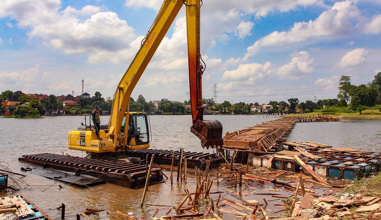 Selain membongkar bangunan di atas, Pemerintah Kota Depok juga membongkar pagar pembatas, antara Alun-Alun Wilayah Barat dengan akses jalan menuju Setu Tujuh Muara. Tampak dalam foto, petugas Dinas Sumber Daya Air Pemerintah Provinsi Jawa Barat membongkar tiang pancang beton yang dipasang di Setu Tujuh Muara, Sawangan, Depok, Senin (16/01/2026). (Merdeka.com/Arie Basuki)