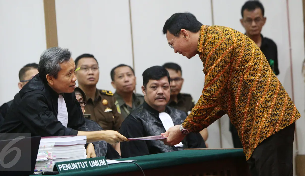 Gubernur DKI Jakarta, Basuki Tjahaja Purnama (Ahok) memberikan berkas saat sidang kasus dugaan penistaan agama di Gedung Kementerian Pertanian, Jakarta, Selasa (25/4). Sidang beragendakan pembacaan pledoi. (Liputan6.com/Miftahul Hayat/Pool)