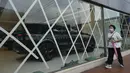Jendela-jendela toko mobil direkatkan sebagai persiapan menghadapi Badai Tropis Kompasu di Hong Kong pada Selasa (12/10/2021). Observatorium Hong Kong mengeluarkan sinyal nomor 8, level tertinggi ketiga dalam skalanya, saat siklon tropis Kompasu semakin mendekati kota. (AP Photo/Vincent Yu)