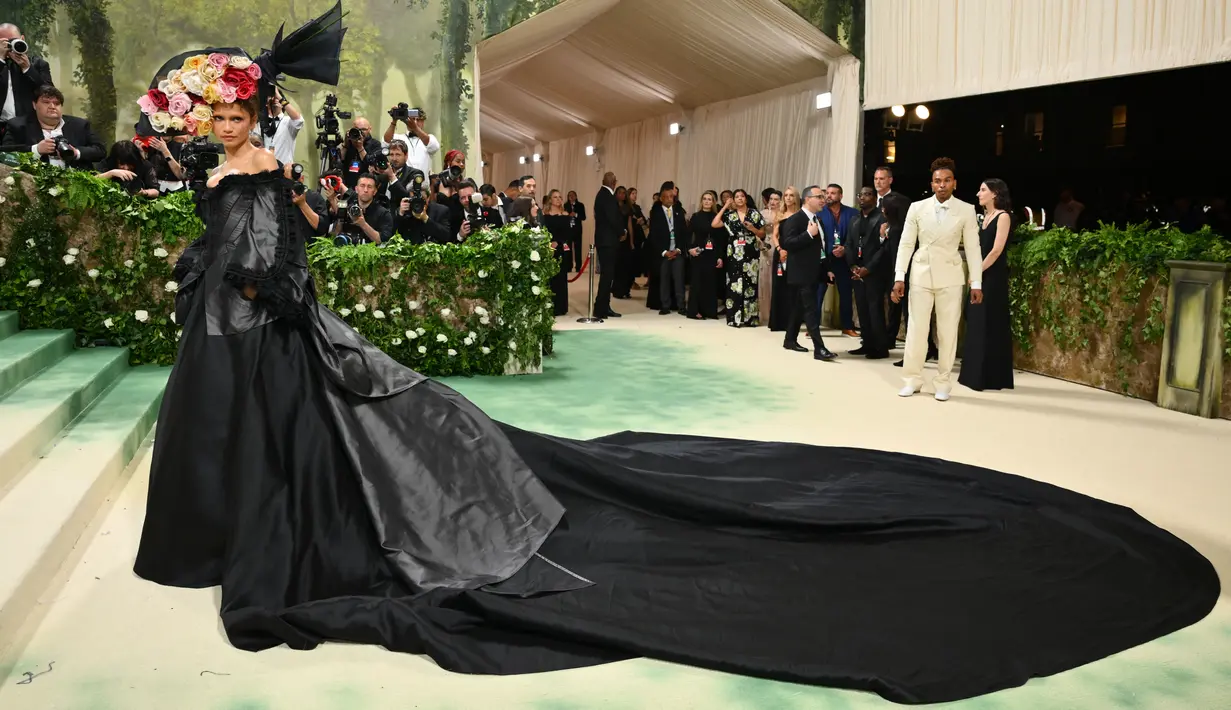 Pemeran serial ‘Euphoria’ itu menggunakan gaun korset bertali dengan lengan off-the-shoulder warna hitam dengan ekor panjang. (Angela WEISS / AFP)