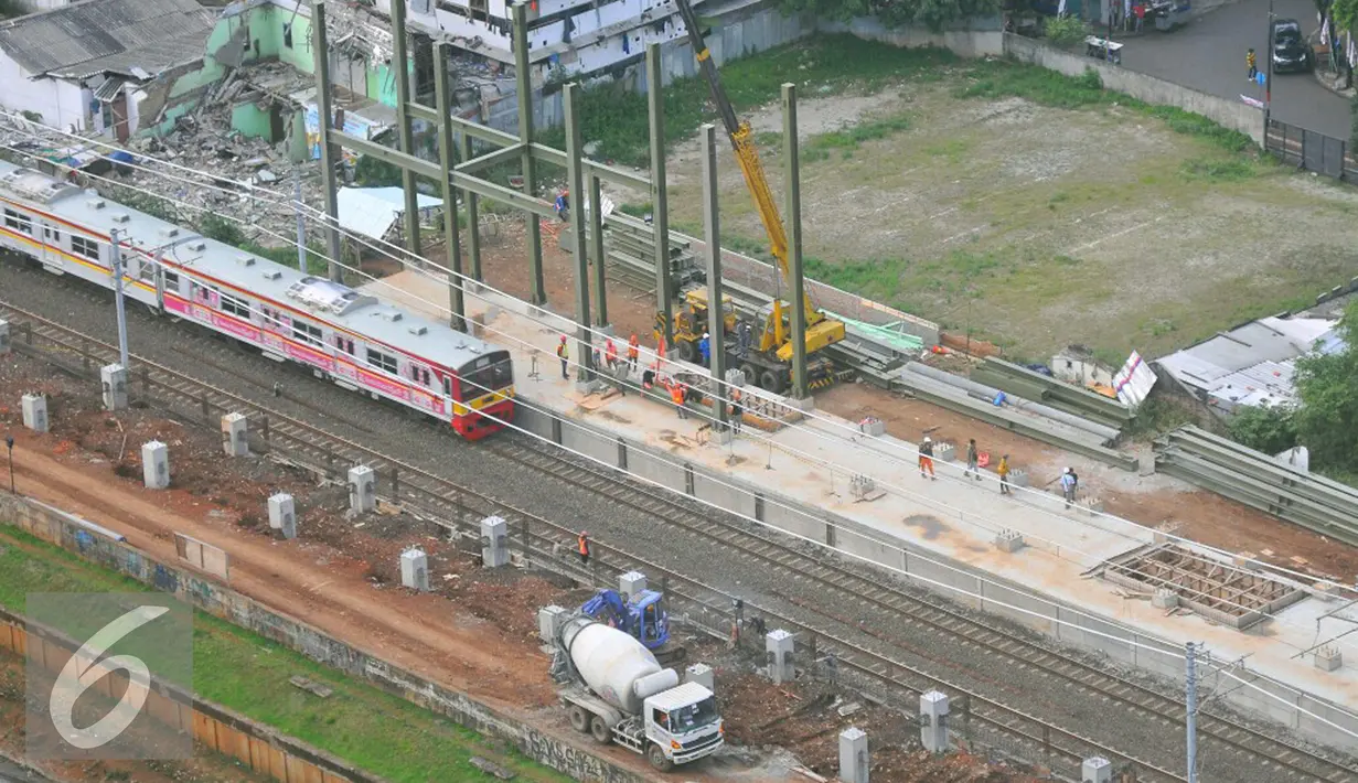 Pemandangan dari atas, pekerja tengah mengerjakan proyek jalur kereta Api Bandara di Jakarta, Rabu (28/12). PT Kereta Api Indonesia menyatakan bahwa pembangunan Kereta Bandara Internasional Soekarno-Hatta masih sesuai rencana. (Liputan6.com/Angga Yuniar)