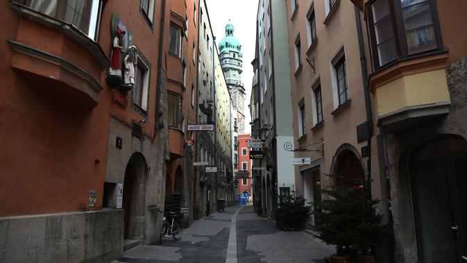 Sebuah sepeda terparkir di jalan sepi di Innsbruck, Austria, Selasa (17/11/2020). Pemerintah Austria telah memberlakukan pengetatan aturan covid-19 yang mencakup penutupan sekolah dan toko-toko nonesensial hingga 6 Desember 2020, seiring gelombang kedua virus corona. (AP/Matthias Schrader)