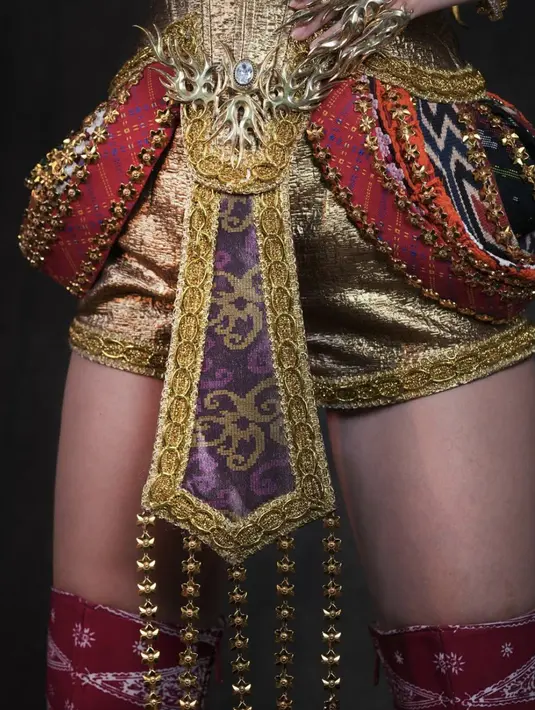 Lenny juga merancang aksesori pelengkap yang melekat di tubuh Clara, meliputi headpiece, aksesori di tangan, jari, dan lainnya. Ia juga mendesain khusus sepatu bot dengan panjang selutut yang terbuat dari tenun merah bermotif tumpal.  [Foto: Instagram/ Hengkikawilarang]