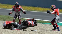 Pembalap Ducati, Andrea Dovizioso dan Jorge Lorenzo berdiri di samping motor mereka setelah mengalami tabrakan pada balapan MotoGP Spanyol 2018 di Sirkuit Jerez, Minggu (6/5). Tabrakan tersebut terjadi di tikungan keenam. (AFP/JAVIER SORIANO)