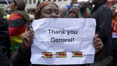 Demonstran memegang kertas bertuliskan "Thank You General" dalam aksi protes di luar Kedutaan Besar Zimbabwe di London, Sabtu (18/11). Warga Zimbabwe yang menetap di Inggris berkumpul mendukung runtuhnya rezim Presiden Robert Mugabe. (NIKLAS HALLE'N/AFP)