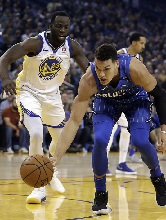 Pemain Orlando Magic, Aaron Gordon (kanan) berusaha melewati pemain Warriors, Draymond Green pada lanjutan NBA Basketball game di Oracle Arena, Oakland, (13/11/2017). Warriors menang 110-100. (AP/Ben Margot)