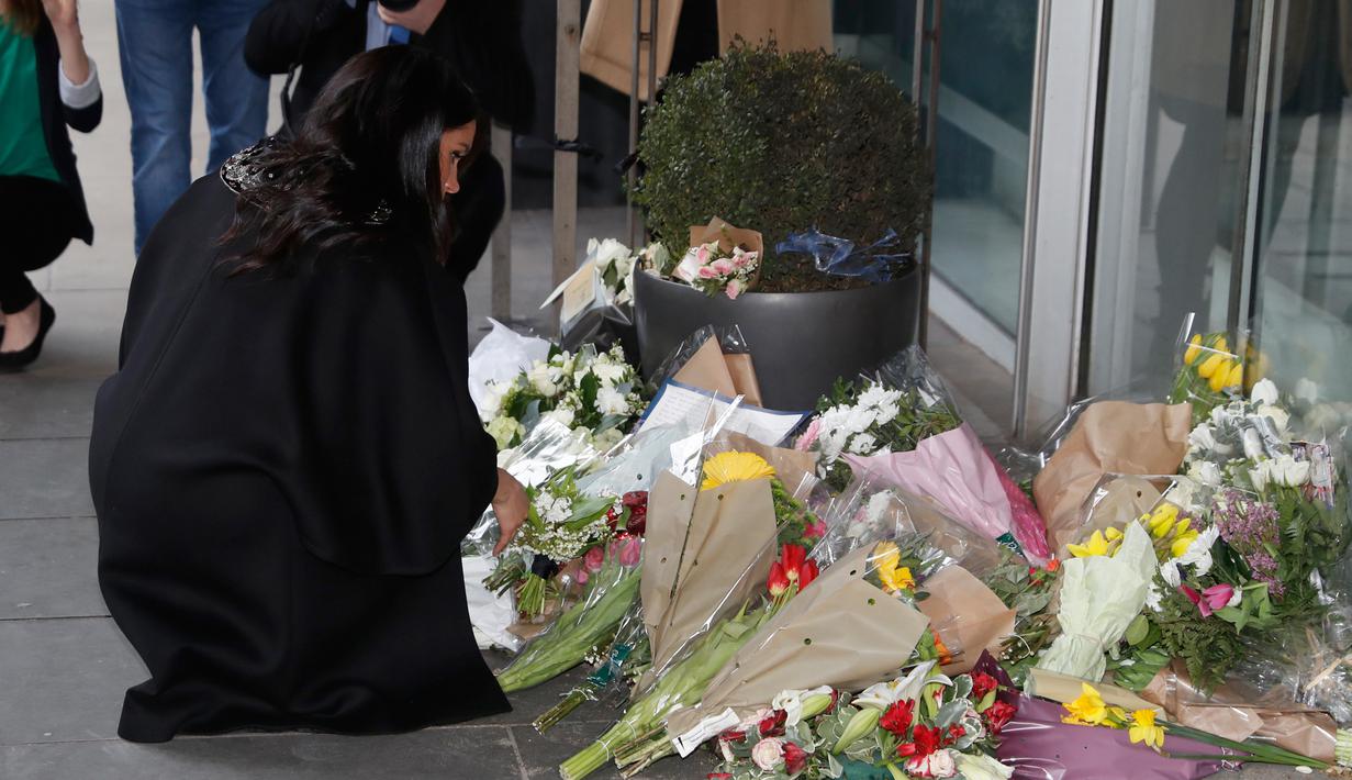 Meghan Markle meletakkan karangan bunga sebagai penghormatan kepada para korban serangan teror di Christchurch saat bersama sang suami, Pangeran Harry, mengunjungi New Zealand House di London, Selasa (19/3). (AP/Alastair Grant)