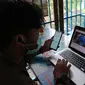 Seorang pewarta menyimak siaran pers Badan Pusat Statistik (BPS) melalui video conference di Jakarta, Senin, (16/3/2020). Inisiatif konferensi pers daring (dalam jaringan) tersebut untuk mencegah penyebaran virus corona Covid-19. (Liputan6.com/Angga Yuniar)