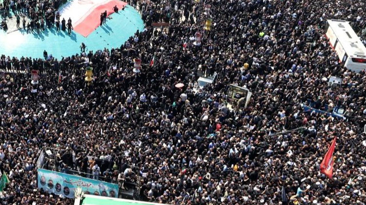 Iring-iringan jenazah Ebrahim Raisi di Teheran disambut jutaan warga berpakaian serba hitam. Suasana penuh duka tampak menyelimuti momen tersebut. Foto:&nbsp;Atta Kenare/AFP
