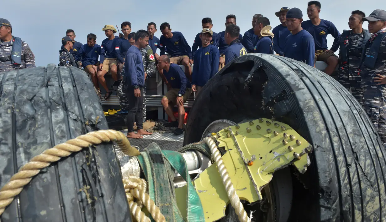 Para penyelam dari tim TNI Angkatan Laut beristirahat setelah berhasil mengangkat roda pesawat Lion Air PK-LQP dengan nomor penerbangan JT 610 yang ditemukan di perairan Tanjung Karawang, Jawa Barat, Jumat (2/11). (ADEK BERRY/AFP)