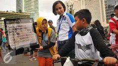 Seorang petugas BNNP memberikan penjelasan tentang narkoba kepada seorang anak di CFD, Jakarta, Minggu (5/2). Soasialisi tersebut dilakukan untuk memberikan pengetahuan kepada masyarakat jenis narkoba dan bahaya narkoba. (Liputan6.com/Angga Yuniar)