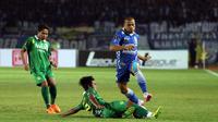 Penyerang Persib, Tantan (kanan) melompat menghindari terjangan pemain Persebaya United,  Putu Gede di laga Grup A Piala Presiden 2015 di Stadion Si Jalak Harupat, Bandung, Minggu (6/9/2015).   Persib unggul 2-0. (Liputan6.com/Helmi Fithriansyah)