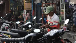 Mekanik mengecek motor pelanggan di sebuah bengkel di Otista, Jakarta, Minggu (10/6). Calon pemudik motor mulai memenuhi bengkel guna menyervis atau mengganti suku cadang kendaraan sebelum digunakan untuk mudik Lebaran. (Liputan6.com/Angga Yuniar)