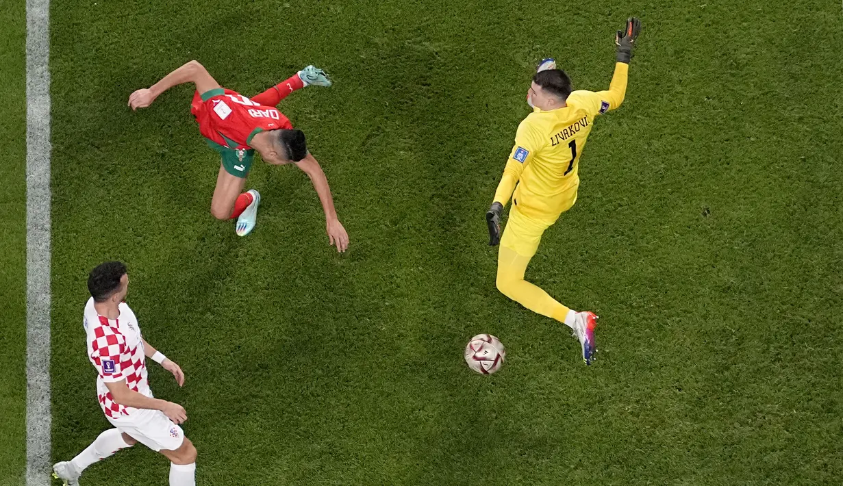 Dua menit berselang Achraf Dari (tengah) berhasil menyundul bola dan mengelabui penjaga gawang Kroasia, Dominik Livakovic (kanan). (AP Photo/Pavel Golovkin)