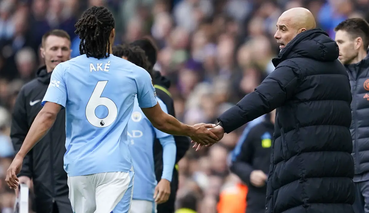 Bek Manchester City, Nathan Ake berjabat tangan dengan pelatih Pep Guardiola ketika berjalan meninggalkan lapangan usai mengalami cedera saat menghadapi Arsenal pada laga pekan ke-30 Premier League 2023/2024 di Etihad Stadium, Manchester, Minggu (31/3/2024). (AP Photo/Dave Thompson)