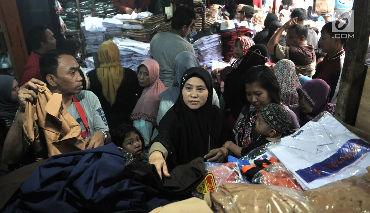 Orangtua memilih seragam sekolah di Pasar Jatinegara, Jakarta, Minggu (14/7/2019). Jelang tahun ajaran baru, Pasar Jatinegara ramai didatangi para orangtua yang mencari seragam sekolah untuk anaknya. (merdeka.com/Iqbal Nugroho)
