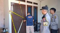 Petugas Kepolisian dari Polresta Bandar Lampung memasang garis polisi di rumah seorang karyawati biro jasa yang diduga jadi korban pembunuhan (Liputan6.com/Ardi Munthe)