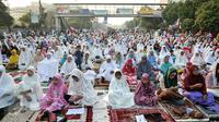 Umat muslim mendengarkan khutbah saat pelaksanaan salat Idul Fitri di kawasan Jatinegara, Jakarta, Rabu (6/7). Ruas Jalan Jatinegara Barat disulap menjadi tempat pelaksanaan salat. (Liputan6.com/Yoppy Renato)