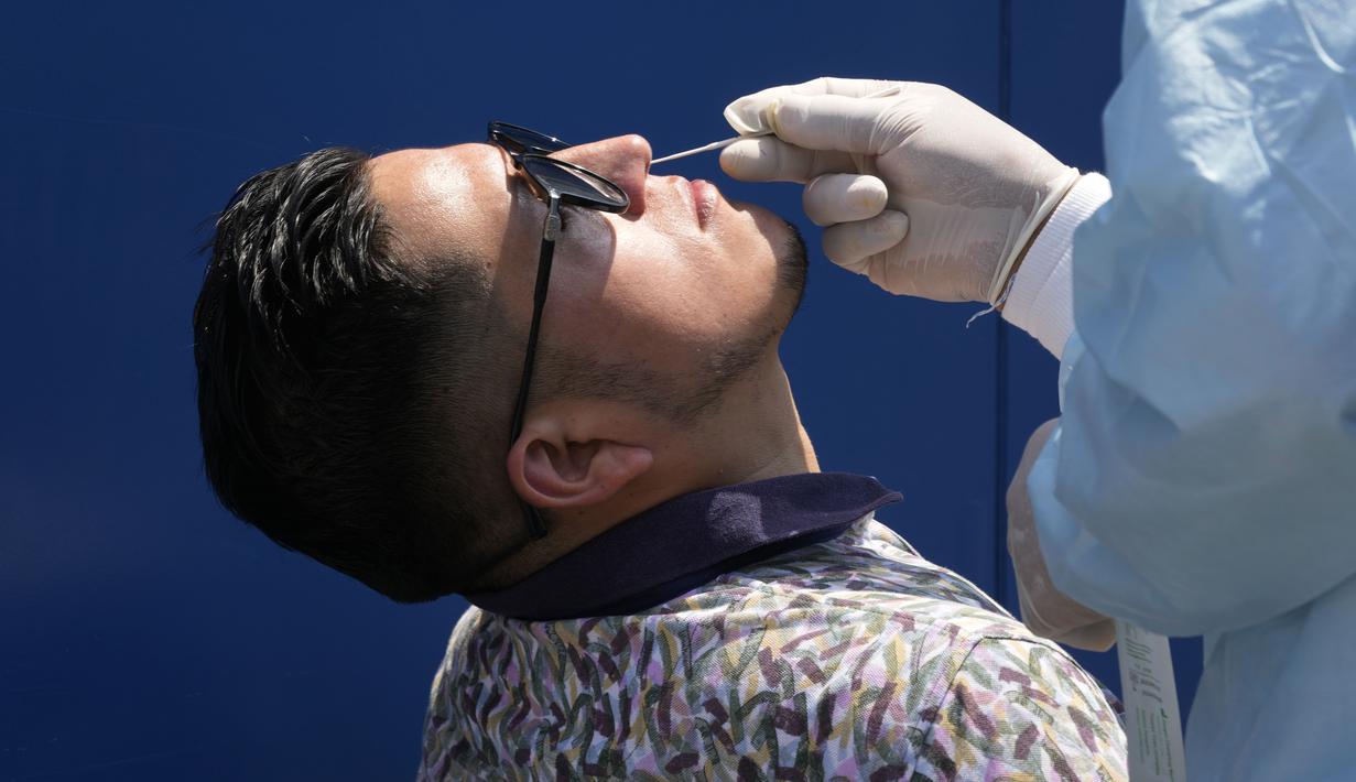 Petugas medis mengambil sampel untuk tes PCR COVID-19 di sebuah pasar di Lima, Peru, Rabu (5/1/2022). Peru mengonfirmasi pada Selasa dimulainya gelombang ketiga infeksi virus corona di mana negara itu mencatat 309 kasus varian omicron yang sangat menular. (AP Photo/Martin Mejia)